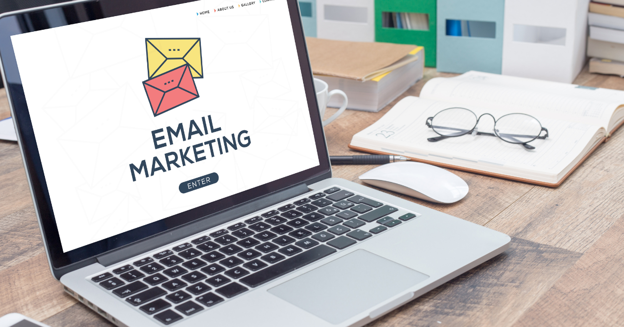 Professional email marketing setup with laptop and marketing materials on display.
